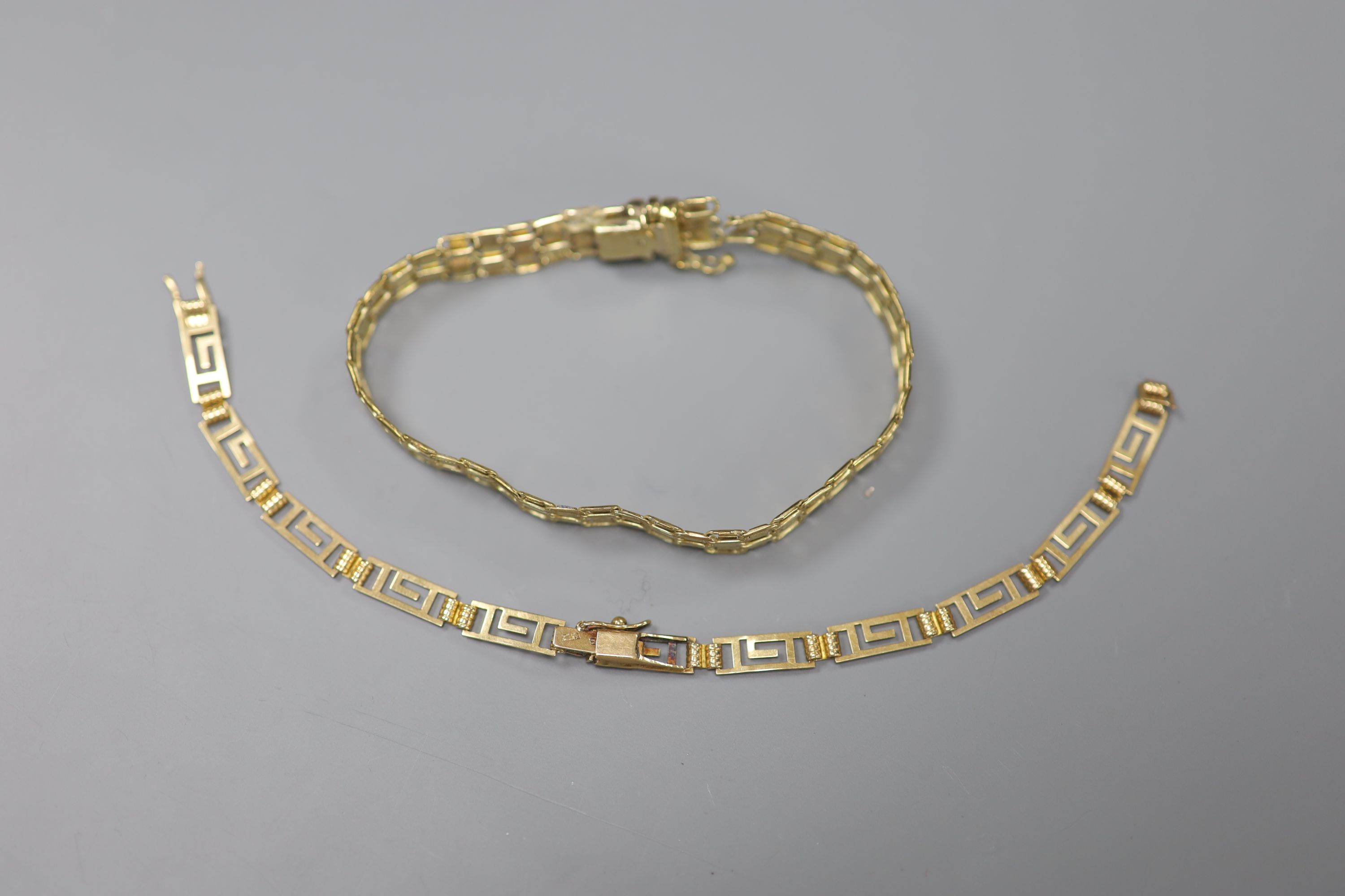 A 9ct plain and textured gold fancy link bracelet, 10.9g and a 585 yellow metal Greek key link bracelet (a.f.), 4.7g.